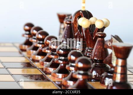 Pezzi di scacchi bianchi disposti sulla scacchiera prima dell'inizio azione di gioco come esercito prima della guerra Foto Stock