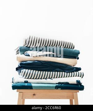 Asciugamani, coperte e altri tessuti domestici in blu e beidge colori si piegano sullo sgabello Foto Stock