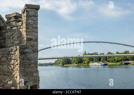 Parte del muro della porta d'acqua medievale (Waterpoortje / Wyck) accanto al fiume Maas (Mosa), con il Ponte alto (Hoge Brug) sullo sfondo in M. Foto Stock