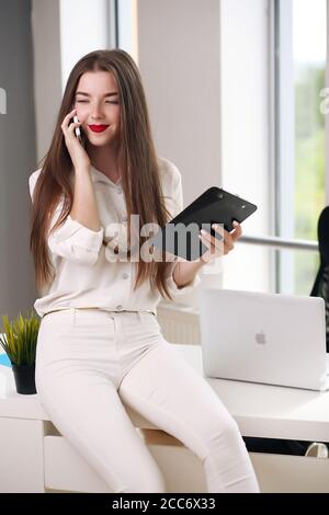 Concentrata giovane donna d'affari intelligente utilizzando il suo computer in ufficio. Foto Stock