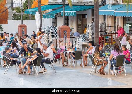 Huelva, Spagna - 17 agosto 2020: Persone sedute in terrazza di un bar e caffè il villaggio di Valverde del Camino. La maggior parte di loro non indossano protezioni Foto Stock