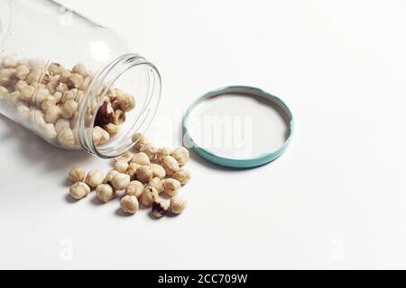 versamento di ceci da un vaso di vetro su sfondo bianco. foto prodotto Foto Stock