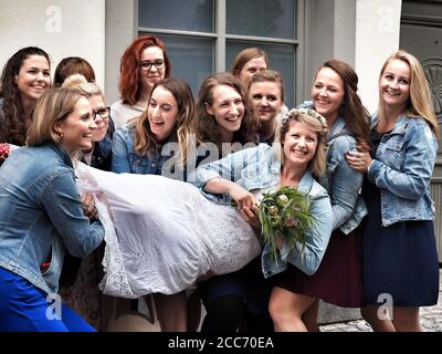 GUMPOLDSKIRCHEN, AUSTRIA - 09/01/2018. Felice sposa caucasica tra bridesmaids ridenti. Foto Stock