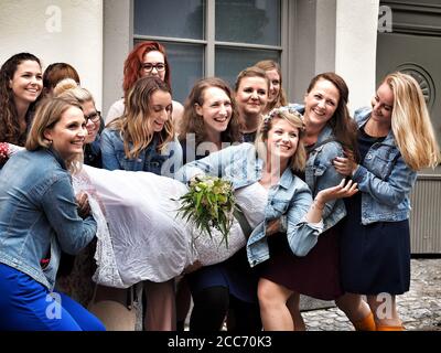 GUMPOLDSKIRCHEN, AUSTRIA - 09/01/2018. Felice sposa caucasica tra bridesmaids ridenti. Foto Stock