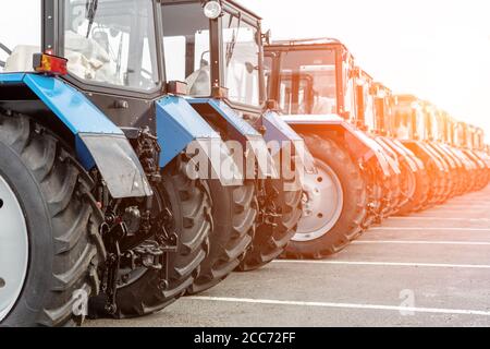 Molti trattori differenti che si levano in piedi in fila alla fiera agricola per la vendita outdoors.Equipment per l'agricoltura.macchine industriali pesanti presentate ad un Foto Stock