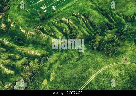 Verdi colline e burroni visti dall'alto, naturale estate sfondo stagionale dal drone Foto Stock