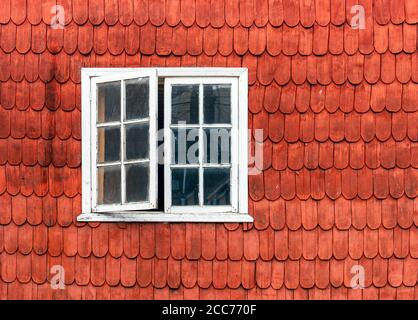 Tradizionale costruzione di alloggi nel distretto lacustre del Cile in legno di larice con una facciata e una finestra aperta, Castro, Chiloe Island, Cile. Foto Stock