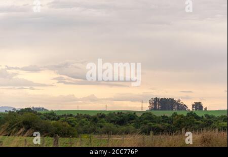 Pampa biome regione nel sud del Brasile. Crepuscolo nei campi e nelle fattorie dello Stato del Rio Grande do sul. Nuvole di pioggia all'orizzonte. Cielo drammatico. Sunse Foto Stock