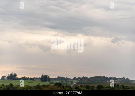 Pampa biome regione nel sud del Brasile. Crepuscolo nei campi e nelle fattorie dello Stato del Rio Grande do sul. Nuvole di pioggia all'orizzonte. Cielo drammatico. Sunse Foto Stock