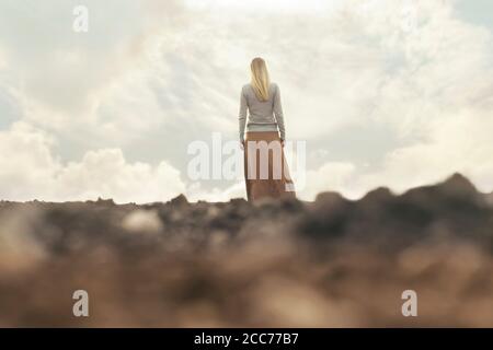 donna solitaria che cammina verso l'infinito in un luogo surreale Foto Stock