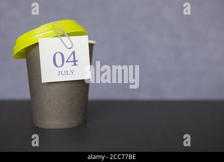 Tazza di carta da caffè con date di calendario per il 04 luglio, stagione estiva. Tempo per pause rilassanti e vacanze. Foto Stock