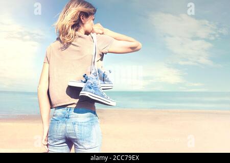 donna che cammina a piedi nudi sulla spiaggia in libertà Foto Stock