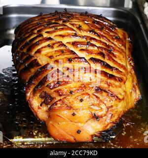 prosciutto di gammon glassato al miele con erbe tradizionali e spezie a. vassoio per tostatura Foto Stock
