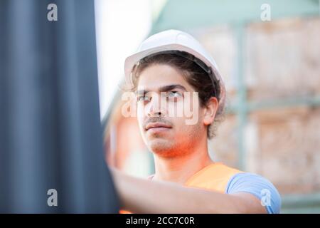 giovane lavoratore del negozio con casco che lavora in un negozio Foto Stock