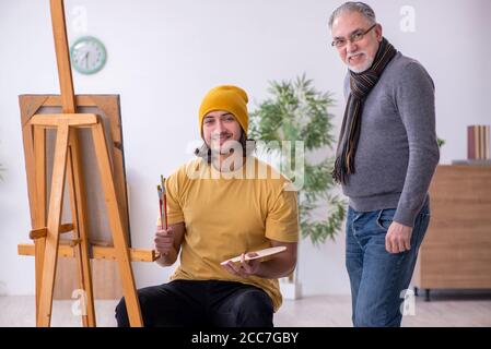 Giovane uomo che prende lezione da pittore esperto Foto Stock