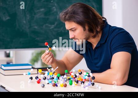 Giovane scienziato seduto in classe Foto Stock