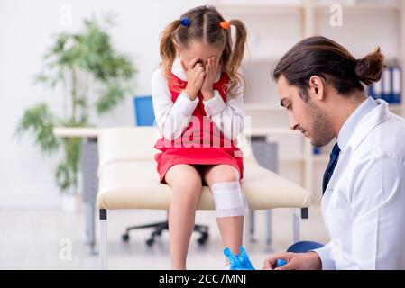 Piccola ragazza che visita giovane medico Foto Stock