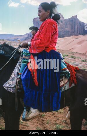 Navaho Indian Woman a cavallo in abito tradizionale, Monument Valley, Arizona, Stati Uniti. Fotografato agosto 1963. Foto Stock