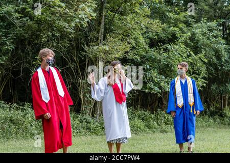 Immagine senior degli studenti delle scuole superiori che si divaricano sociale indossando il cappuccio E abito con maschera in Kentucky Foto Stock