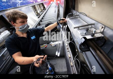 Monaco, Germania. 17 agosto 2020. Christian Hacker, un dipendente di Stadtwerke München, installa lampade UV su una scala mobile a Marienplatz S-Bahn e U-Bahn. Stadtwerke München (SWM) e Münchner Verkehrsgesellschaft (MVG) stanno conducendo un test a lungo termine per esaminare la disinfezione dei corrimano sulle scale mobili con luce UV. Credit: Sven Hoppe/dpa/Alamy Live News Foto Stock