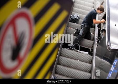 Monaco, Germania. 17 agosto 2020. Christian Hacker, un dipendente di Stadtwerke München, installa lampade UV su una scala mobile a Marienplatz S-Bahn e U-Bahn. Stadtwerke München (SWM) e Münchner Verkehrsgesellschaft (MVG) stanno conducendo un test a lungo termine per esaminare la disinfezione dei corrimano sulle scale mobili con luce UV. Credit: Sven Hoppe/dpa/Alamy Live News Foto Stock