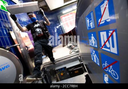 Monaco, Germania. 17 agosto 2020. Emilijan Stamfar, un dipendente di Stadtwerke München, installa lampade UV su una scala mobile a Marienplatz S-Bahn e U-Bahn. Stadtwerke München (SWM) e Münchner Verkehrsgesellschaft (MVG) stanno conducendo un test a lungo termine per esaminare la disinfezione dei corrimano sulle scale mobili con luce UV. Credit: Sven Hoppe/dpa/Alamy Live News Foto Stock