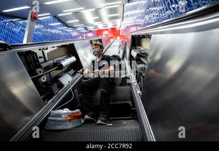 Monaco, Germania. 17 agosto 2020. Christian Hacker, un dipendente di Stadtwerke München, installa lampade UV su una scala mobile a Marienplatz S-Bahn e U-Bahn. Stadtwerke München (SWM) e Münchner Verkehrsgesellschaft (MVG) stanno conducendo un test a lungo termine per esaminare la disinfezione dei corrimano sulle scale mobili con luce UV. Credit: Sven Hoppe/dpa/Alamy Live News Foto Stock