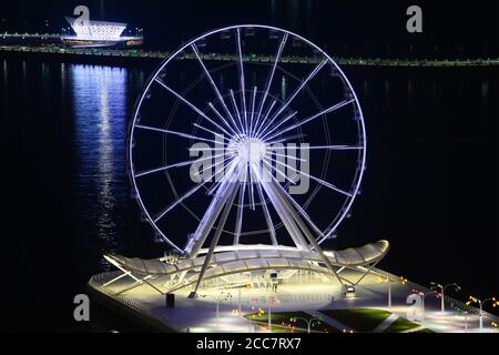 Ruota panoramica di Baku situata su Baku Boulevard in Azerbaigian. Baku Eye che gira di notte. Esposizione prolungata della ruota in ferro. Foto Stock