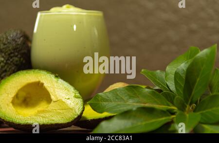 American persea. Crema di avocado. Frutta tropicale. Guacamole. Avocado intero e a metà. Pasta di avocado verde. Dessert. Delicatezza culinaria. Cibo naturale. Foto Stock