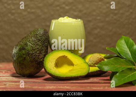 American persea. Crema di avocado. Frutta tropicale. Guacamole. Avocado intero e a metà. Pasta di avocado verde. Dessert. Delicatezza culinaria. Cibo naturale. Foto Stock