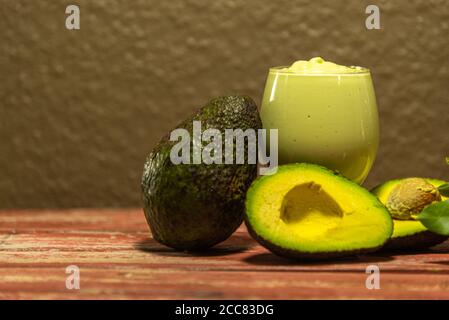 American persea. Crema di avocado. Frutta tropicale. Guacamole. Avocado intero e a metà. Pasta di avocado verde. Dessert. Delicatezza culinaria. Cibo naturale. Foto Stock