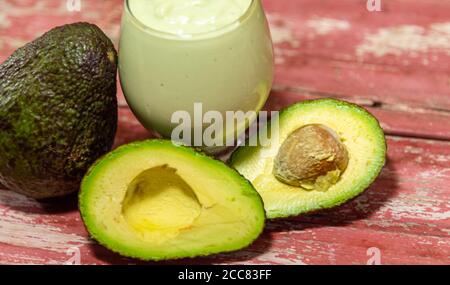 American persea. Crema di avocado. Frutta tropicale. Guacamole. Avocado intero e a metà. Pasta di avocado verde. Dessert. Delicatezza culinaria. Cibo naturale. Foto Stock