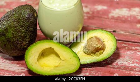 American persea. Crema di avocado. Frutta tropicale. Guacamole. Avocado intero e a metà. Pasta di avocado verde. Dessert. Delicatezza culinaria. Cibo naturale. Foto Stock