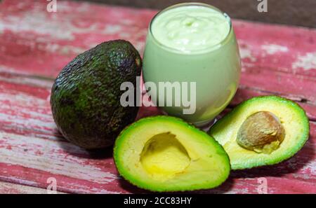 American persea. Crema di avocado. Frutta tropicale. Guacamole. Avocado intero e a metà. Pasta di avocado verde. Dessert. Delicatezza culinaria. Cibo naturale. Foto Stock