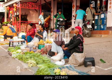 Thailandia: Akha commercianti al mercato di mattina presto vicino alla stazione di benzina locale in Doi Mae Salong (Santikhiri), provincia di Chiang Rai. Gli Akha sono una tribù collinare di contadini di sussistenza noti per la loro arte. Gli Akha sono distribuiti in piccoli villaggi tra le montagne della Cina, del Laos, del Myanmar (Birmania) e della Thailandia settentrionale. Doi Mae Salong era un tempo un impoverito, pesantemente armato Kuomintang (KMT) avamposto, è oggi una tranquilla oasi di giardini del tè, frutteti e case in stile Yunnanese. Foto Stock