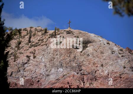 Una croce cristiana sulla cima di una montagna nella Quebrada de Humahuaca, patrimonio dell'umanità dell'UNESCO, San Francisco de Tilcara, provincia di Jujuy, Argentina. Foto Stock