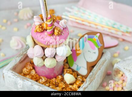 Frullato shake decorato come unicorno nella scatola di legno riempito con popcorn Foto Stock