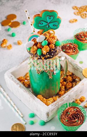 Frullato verde agitare con biscotti trifoglio in scatola di legno riempito con popcorn Foto Stock