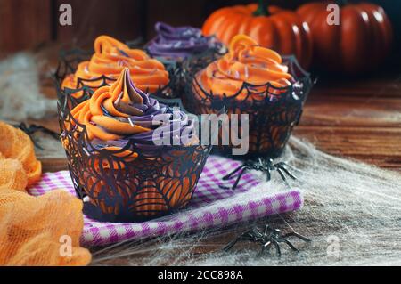 Cupcakes di Halloween su tavolo rustico di legno coperto di rete Foto Stock