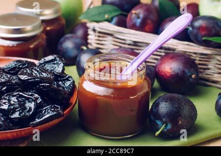 Vasetto con purea di prugne per alimenti per bambini con cucchiaio quasi fresco prugne Foto Stock