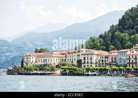 Skyline di Bellagio. Italia. Molo dei traghetti. Vista panoramica dal Lago di Como con le Alpi. Mattina. Cielo nuvoloso. Foto Stock