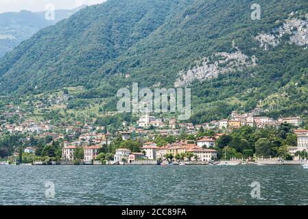 Lungomare del comune di Mezzegra sul Lago di Como. Lombardia. Italia. Panorama con montagne e foresta. Foto Stock