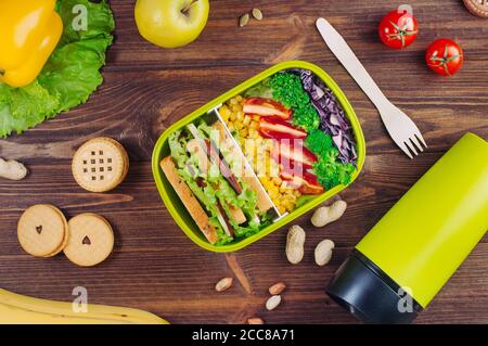 Pranzo al sacco con verdure e sandwich vicino thermos tazza Foto Stock