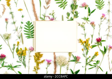 Apri il notebook con spazio vuoto per il testo su sfondo di fiori selvatici Foto Stock