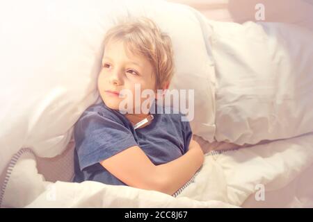 bambino malato a letto con febbre e termometro Foto Stock