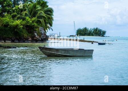 Moreea, Polinesia francese: 09/03/2018: Una piccola casa di legno e una piccola nave sulla spiaggia di bellezza bianca di Moorea con alberi tropicali e un ocea trasparente Foto Stock