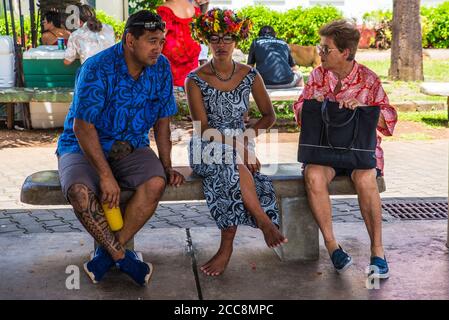 Moorea, Polinesia francese: 09/03/2018: Persone locali seduti e parlando nel loro momento di riposo, vestono fiori e lavorano con perle e pesca. Tropi Foto Stock