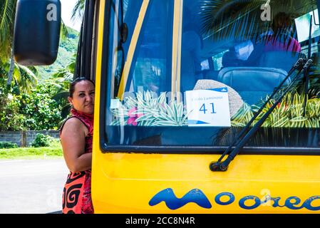 Moorea, Polinesia Francese: 09/03/2018: Una donna locale che aspetta accanto all'autobus per mostrare l'isola tropicale ai turisti. Paradiso in Polinesia francese Foto Stock