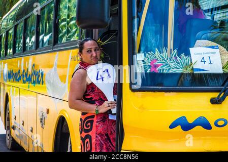 Moorea, Polinesia Francese: 09/03/2018: Una donna locale che aspetta accanto all'autobus per mostrare l'isola tropicale ai turisti. Paradiso in Polinesia francese Foto Stock