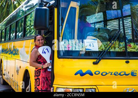 Moorea, Polinesia Francese: 09/03/2018: Una donna locale che aspetta accanto all'autobus per mostrare l'isola tropicale ai turisti. Paradiso in Polinesia francese Foto Stock